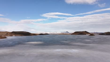 Frozen Lake Mývatn near Skútustaðir and Reykjahlíð, Iceland. Snow-capped pseudocraters surround the icy expanse under a vast sky, evoking Arctic calm and untouched beauty.