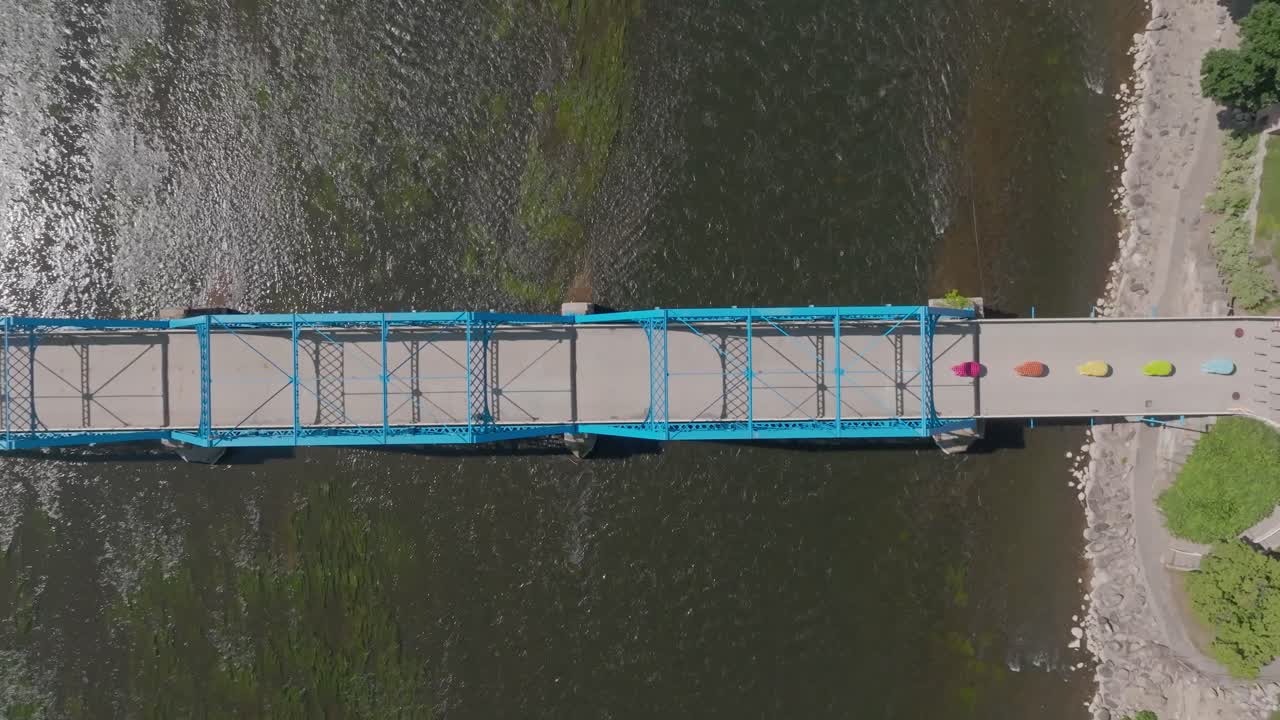 puente azul sobre el río grand en el centro de grand rapids, michigan con video de avión no tripulado por encima moviéndose hacia abajo