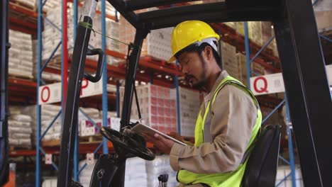 Young-man-working-in-a-warehouse-sitting-in-forklift-4k
