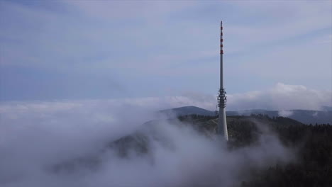 影像: 大型廣播塔從空中拍攝, 穿過雲端, 坐在黑森林山上, 在明亮的秋天