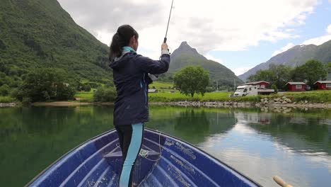 Frau-Auf-Dem-Boot-Fängt-Einen-Fisch-Beim-Spinnen-In-Norwegen.