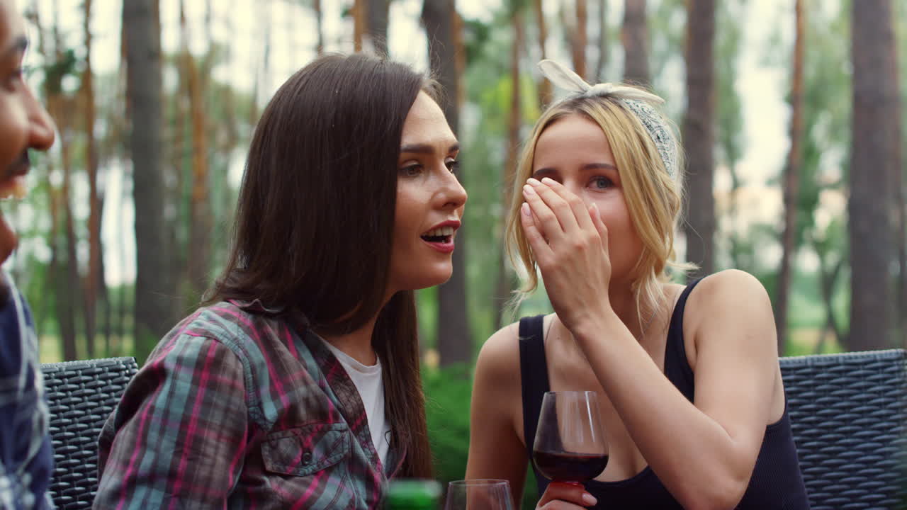 뒷마당에서 비밀을 공유하는 젊은 여성들. 야외 파티에서 채팅하는 소녀들