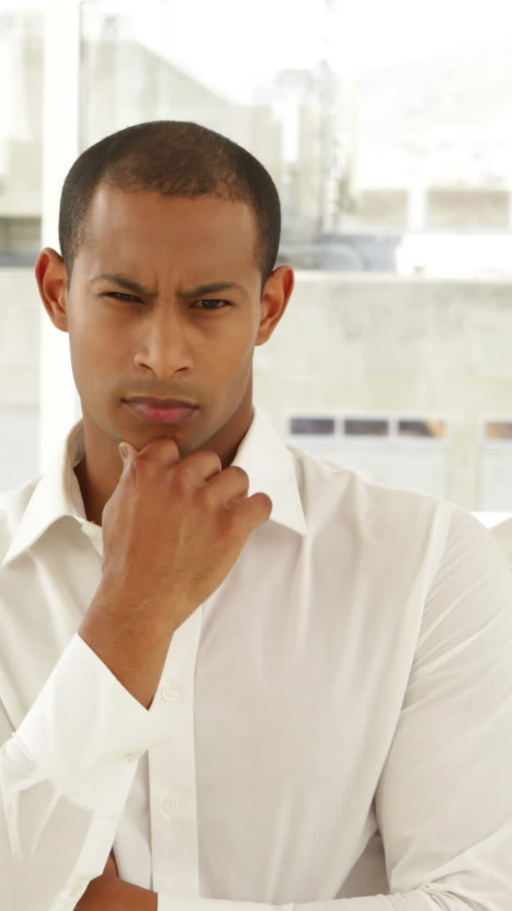 hombre de negocios mirando a la cámara con el personal detrás de él