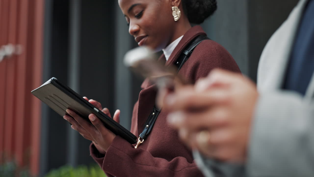 A woman and a man using their tablet and smartphone in the city
