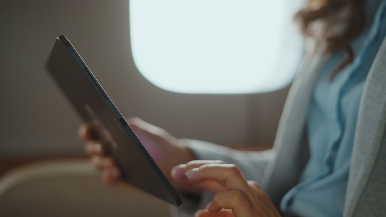 Woman working on tablet during flight