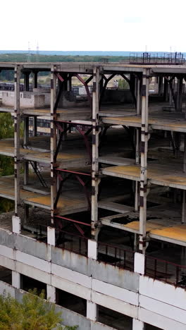 old factory buildings in rural place. abandoned territory with ruined warehouses without windows among green nature.. vertical video