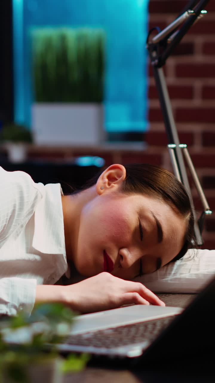 Vertical video Tired employee asleep on computer desk chair suddenly waking up