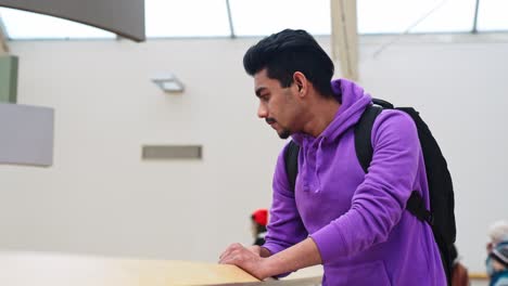 Medium-close-up-of-young-South-Asian-man-observing-around-at-shopping-mall