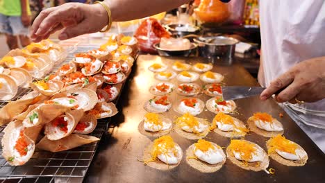 street vendor prepares traditional thai crispy pancakes