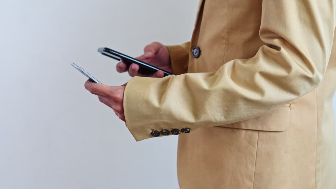 Primo piano di viaggiatore in abito beige che controlla telefono e biglietto per il viaggio.