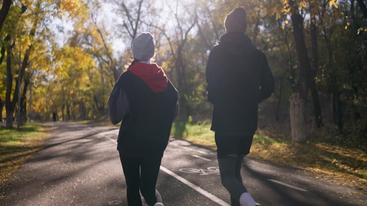 Um casal a correr no Parque de Outono