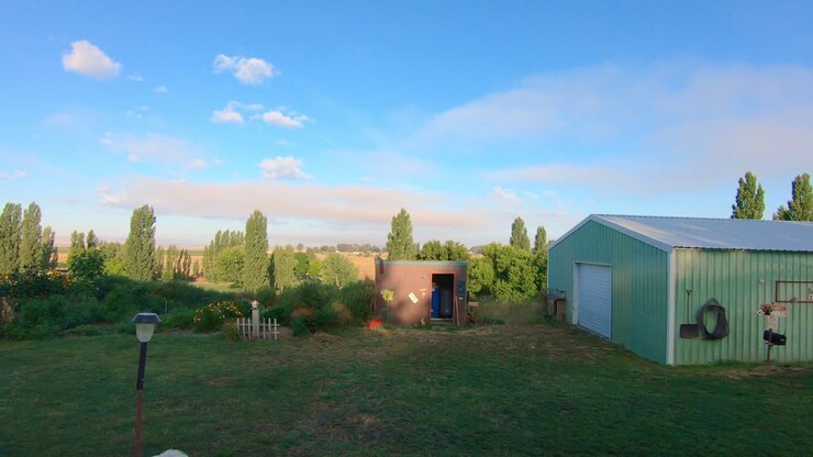Panoramica di fienile, giardino e alberi nel tardo pomeriggio nello Washington orientale
