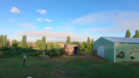 Pan-of-barn,-garden-and-trees-in-late-afternoon-in-eastern-Washington