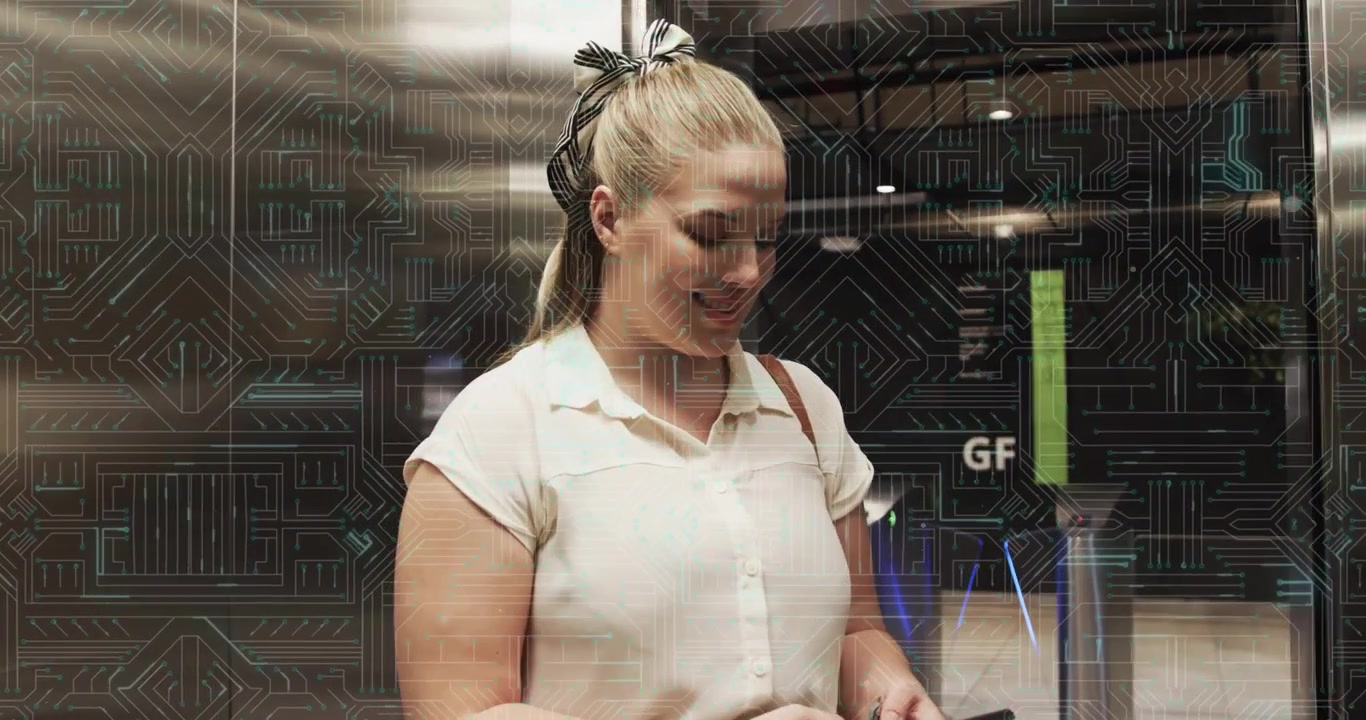 Porte dell'ascensore che si aprono, donna che attraversa il tornello e sblocca il telefono, mostrando notifiche aziendali