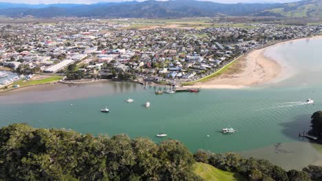 Vista-Panorámica-Aérea-De-La-Ciudad-De-Whitianga-En-Nueva-Zelanda,-Frente-Al-Mar-Con-Puerto-De-Ferry,-Día-Soleado