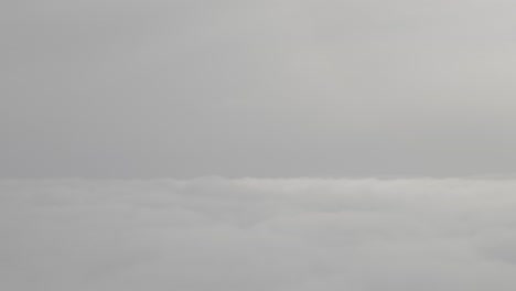 cloudscape view from above, calm gray sky and soft white clouds blending together