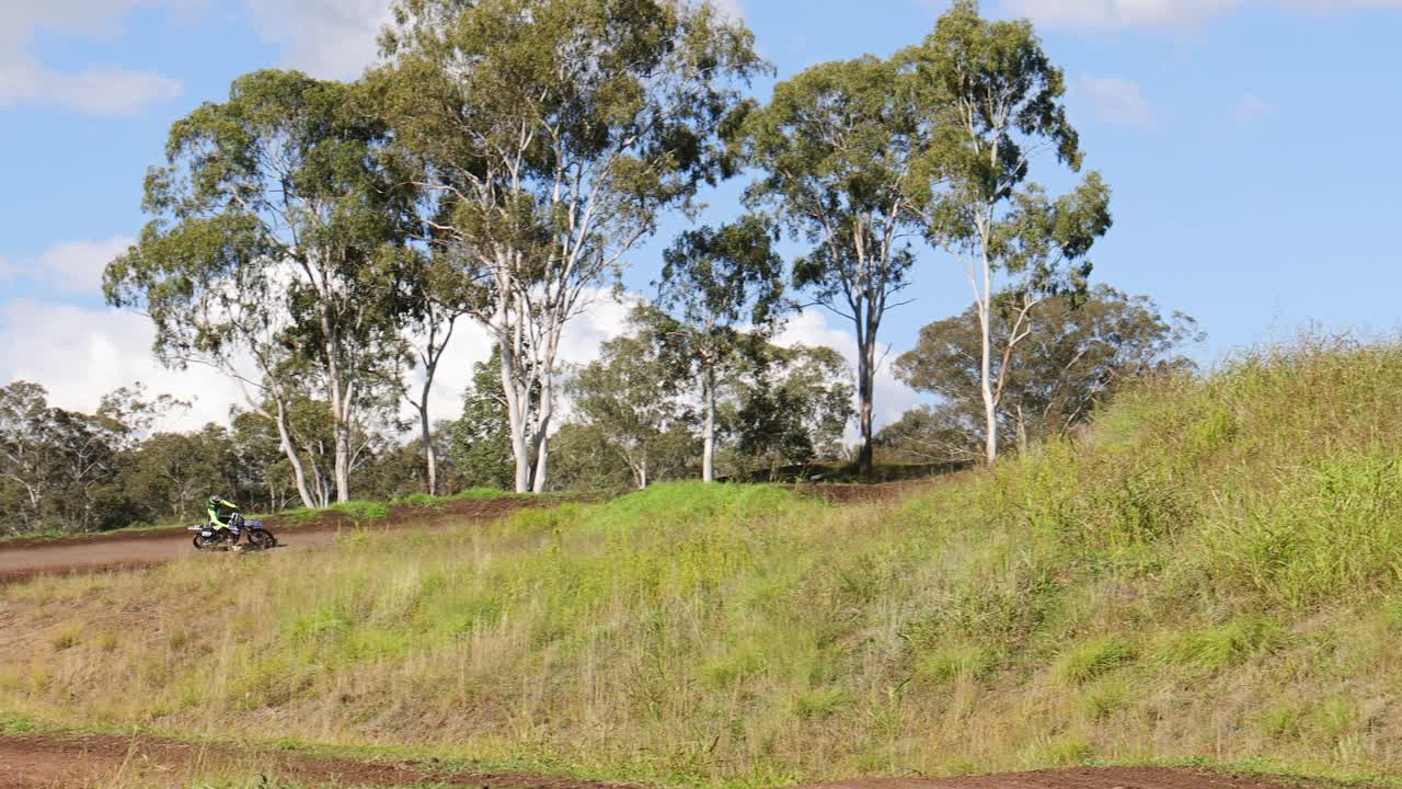 오토바이 운전자 가 풀 과 숲 을 가로질러 달린다