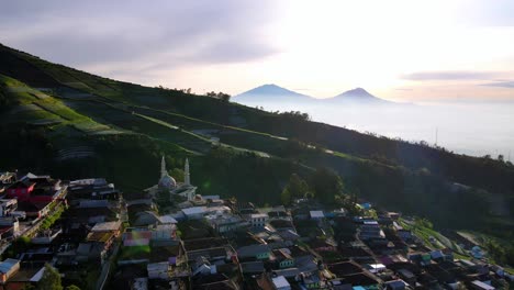 Aerial-backwards-shot-showing-beautiful-mountain-landscape-and-famous-city-on-slope-at-sunset---Nepal-Van-Java,Indonesia