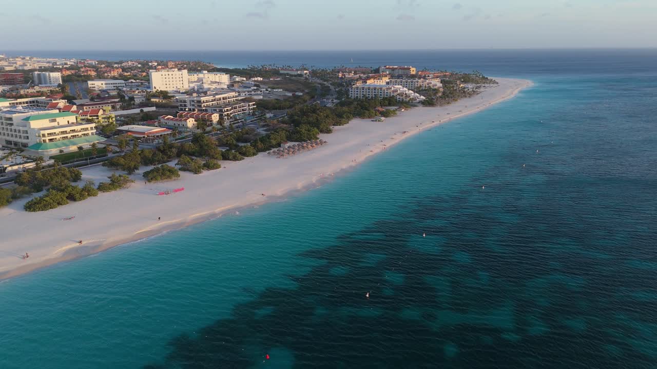 Hotels and trees on the seashore, on Baby Beach, Aruba