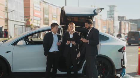 business meeting in front of electric car