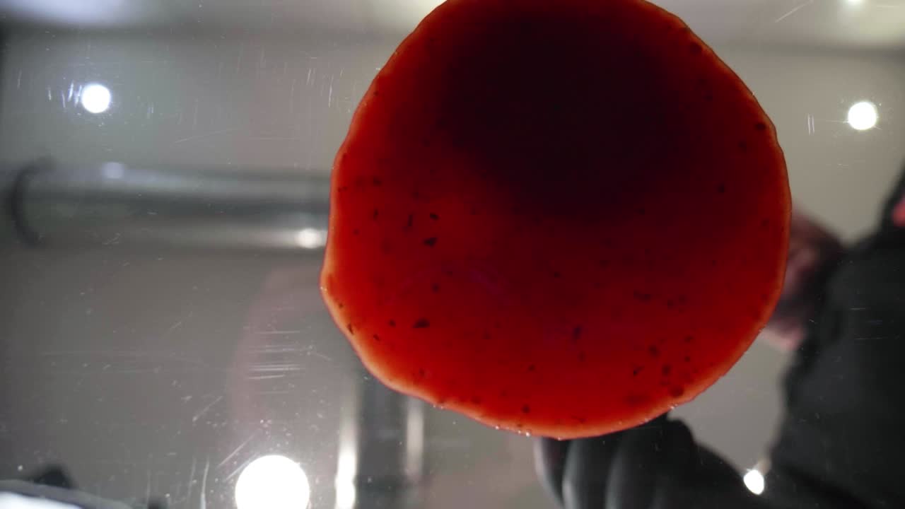 Low angle shot from frog perspective: ladle spreading delicious tomato sauce in a circular motion