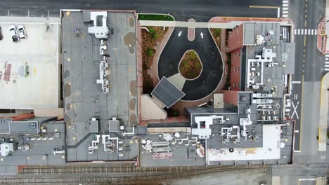 aerial top down view of circle driveway at hotel building, street and car passes by