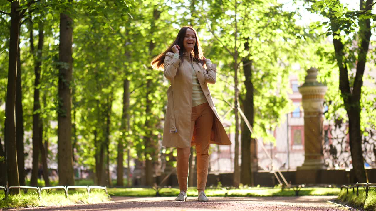 una mujer sonriente bailando en el parque.