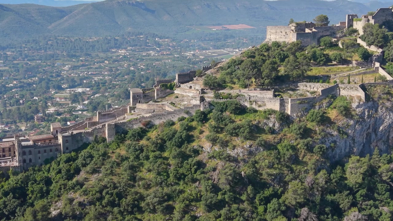 Vista aerea con drone del Castello di Xàtiva che si estende su un aspro fianco di montagna sopra le valli e le foreste di Xàtiva, Spagna.