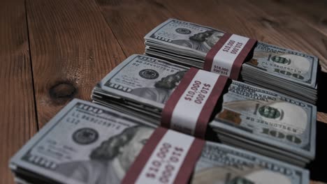 three stacks of 10000 american dollars banknotes in bundles lie on wooden table