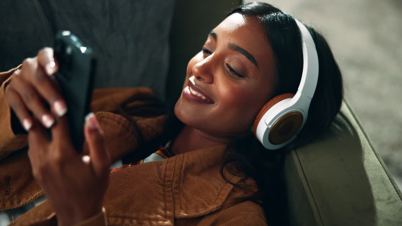 mujer relajándose con auriculares y teléfono