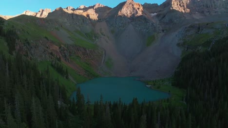 sunset lower blue lake mount sneffels wilderness ridgway telluride colorado aerial drone golden hour shaded peaks san juan rocky mountains uncompahgre national forest last sunlight backward pan motion