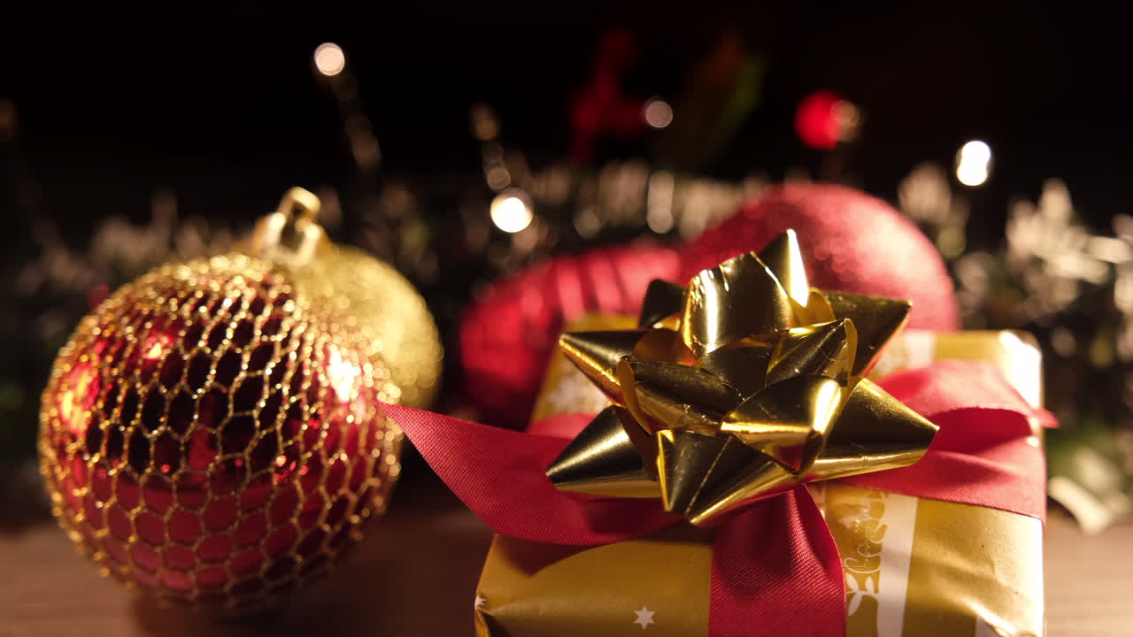 Regalo natalizio dorato e decorazione con nastro rosso e luci