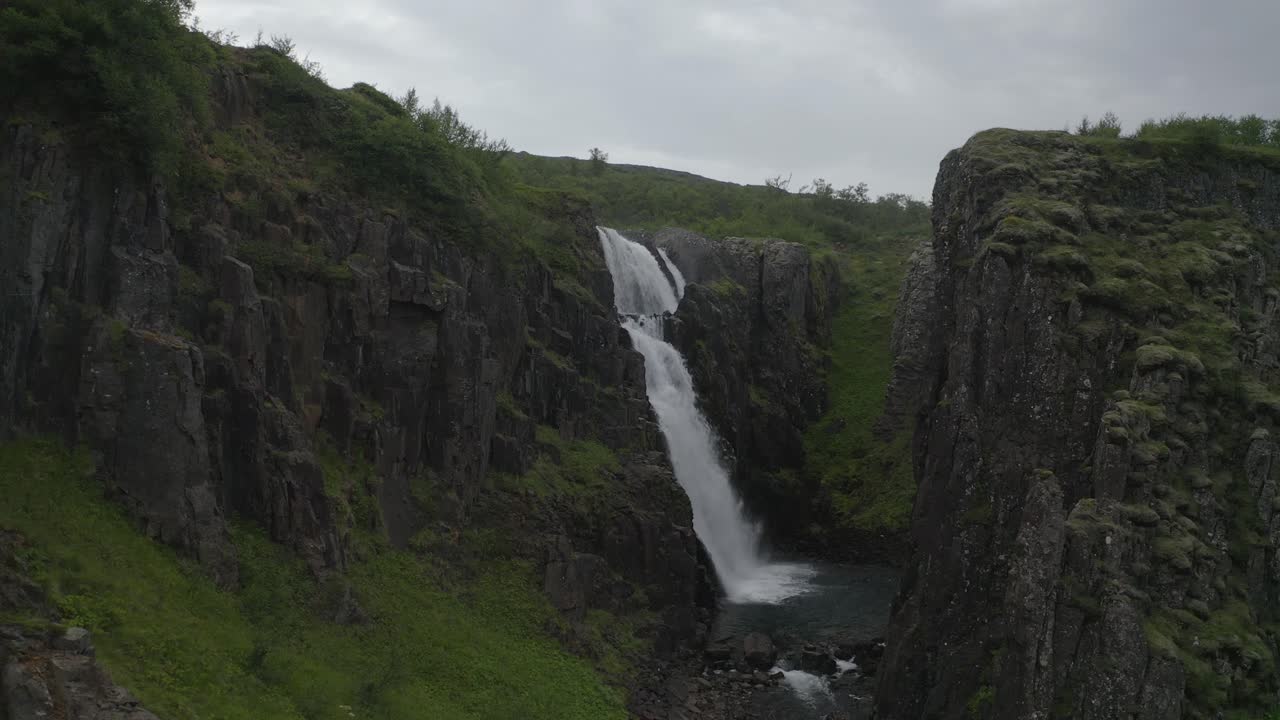 vuelo aéreo hacia la cascada de gufufoss entre acantilados cerca de fardagafoss en el este de islandia