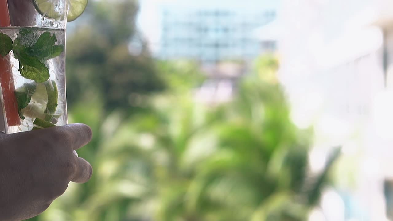 la señora bebe mojito congelado a través de una larga pajita de plástico