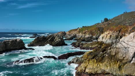 vista aérea sobre as ondas batendo nas rochas ao longo da costa do pacífico, big sur califórnia