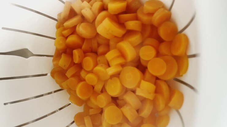 Steaming Slices Of Carrots In Steamer Basket. closeup