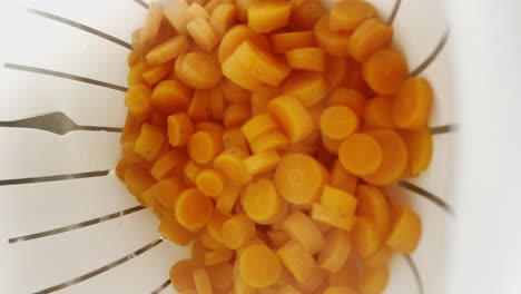 steaming slices of carrots in steamer basket. closeup