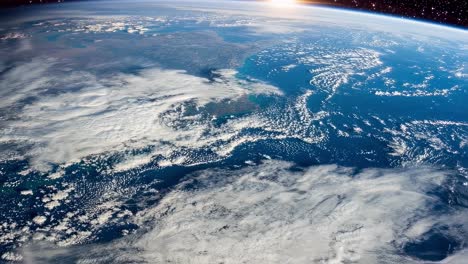planet earth is rotating slowly in the vastness of space, with the sun shining brightly on its surface, illuminating the continents and oceans, creating a breathtaking view of our home