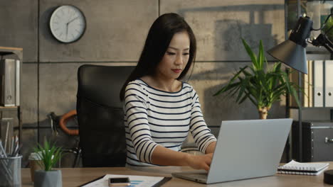 Young-Female-Office-Worker-Working-On-The-Laptop-Computer,-Tapping-And-Resting-In-The-Comfortable-Chair