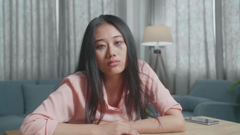 술에 취한 아시아 여성이 집에서 카메라를 보고 있다