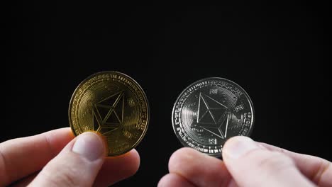 cryptocurrency coins held against a dark background, capturing focus