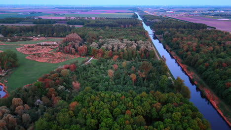 autumn landscape with river and fields. colorful autumn foliage lines a peaceful river while expansive fields stretch into the distance during sunset