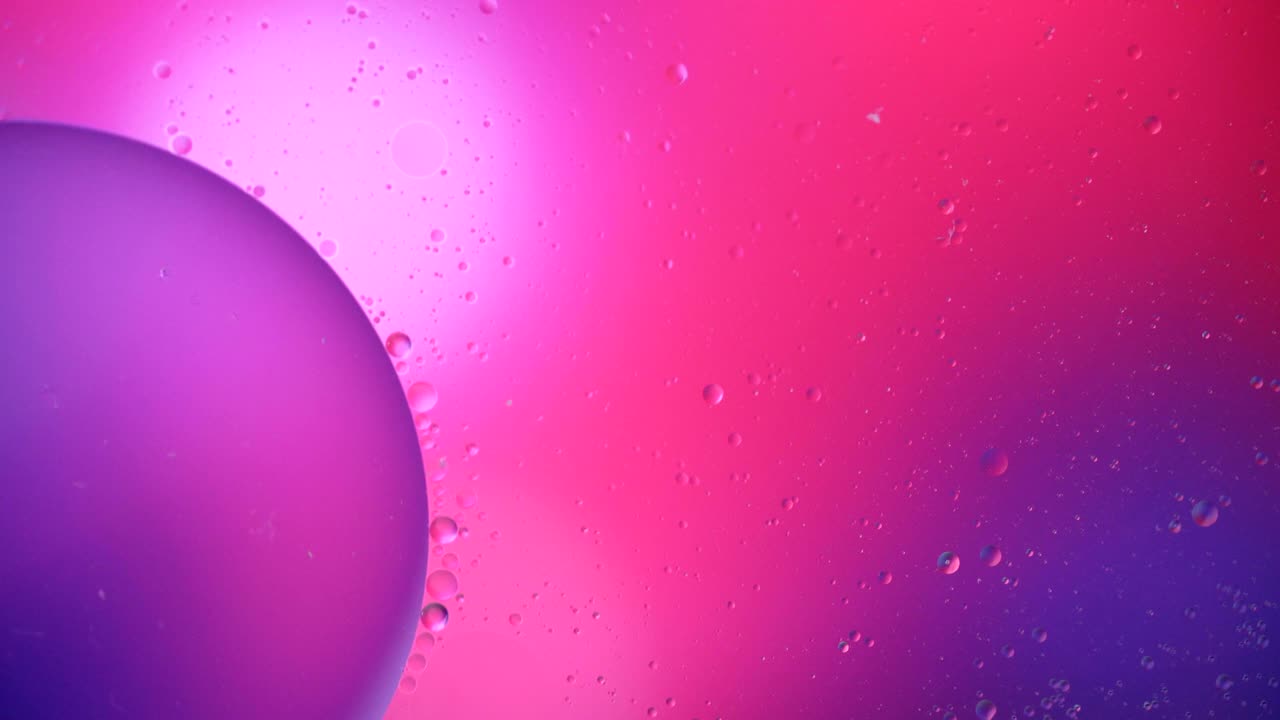 Fantastic structure of colorful bubbles. Chaotic motion. Abstract colorful paint. Top view. Movement of bubbles in the liquid. Oil surface multicolored background. Macro