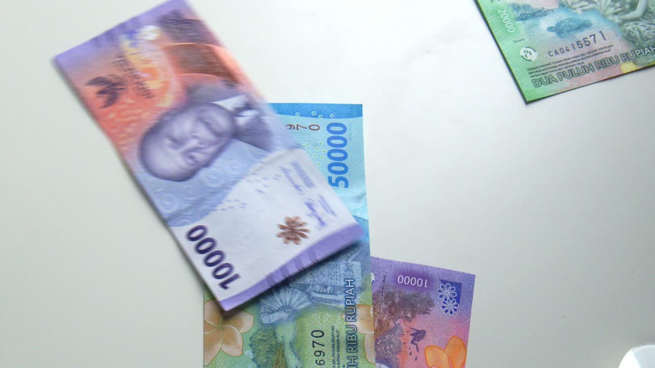 Lançando nota de Rúpia Indonésia em câmera lenta, dinheiro ou notas caindo.