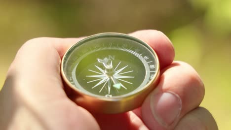 Traveler-hand-holds-a-compass-in-forest