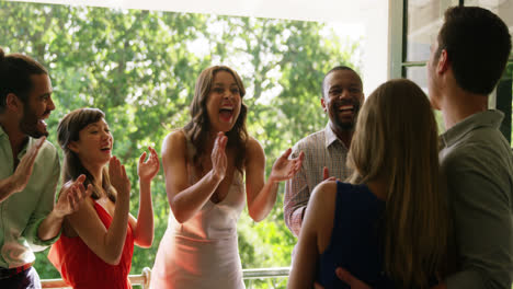 happy couple embracing while friends applauding during party