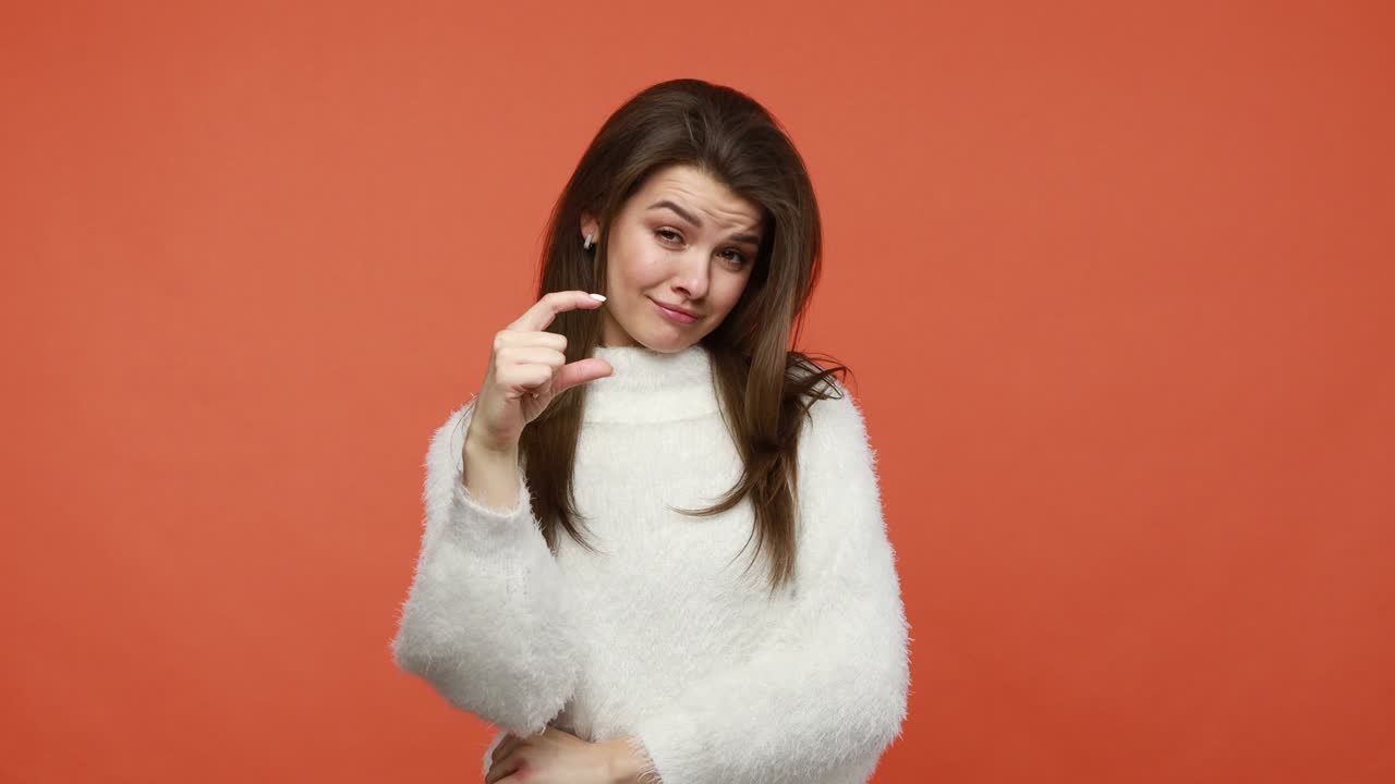 mujer mostrando un pequeño gesto mirando a la cámara con expresión sarcástica