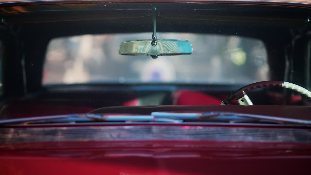 Close up of the inside of a burgundy, retro car parked on the street