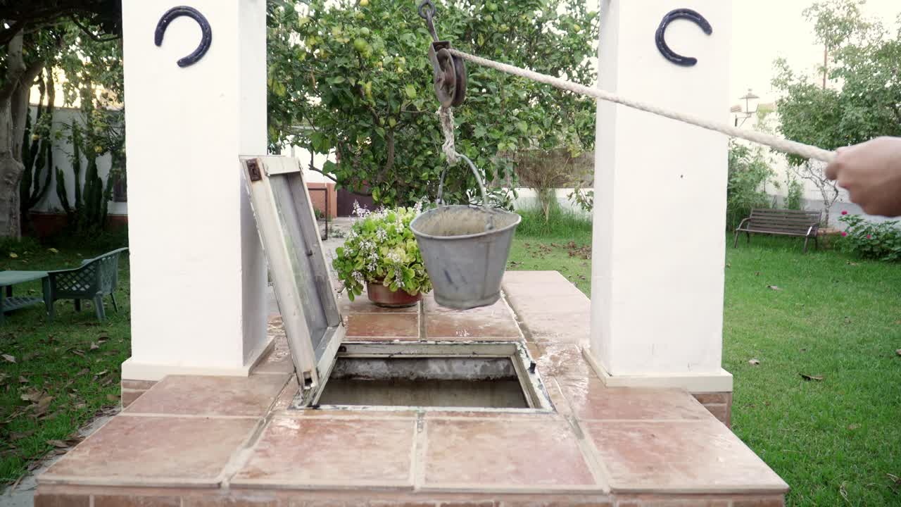 양동이에 묶인 밧줄을 당겨 우물에서 물을 가져오고, 신선한 순수한 식수