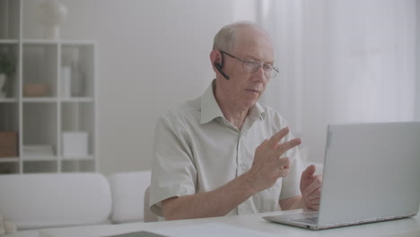 old teacher is lecturing online staying home and communicating with pupils by internet